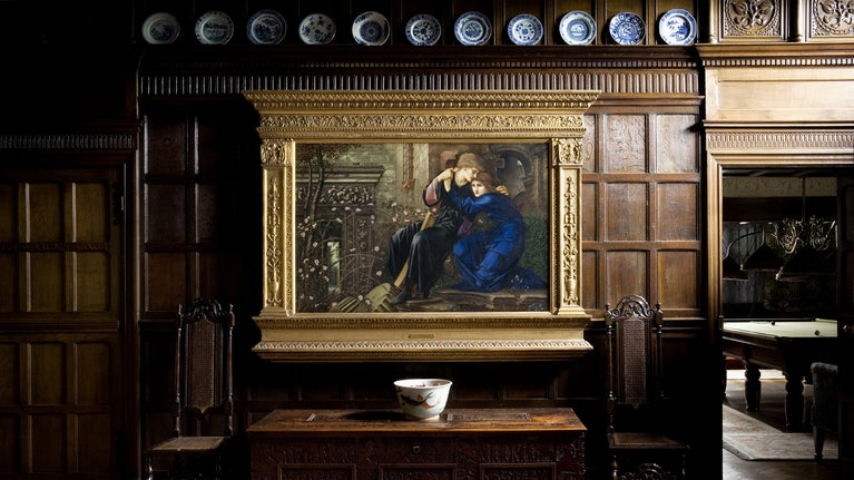 The painting Love among the Ruins, by Sir Edward Coley Burne-Jones (1833-1898), 1894, hangs against the oak panelling of the Great Parlour at Wightwick Manor